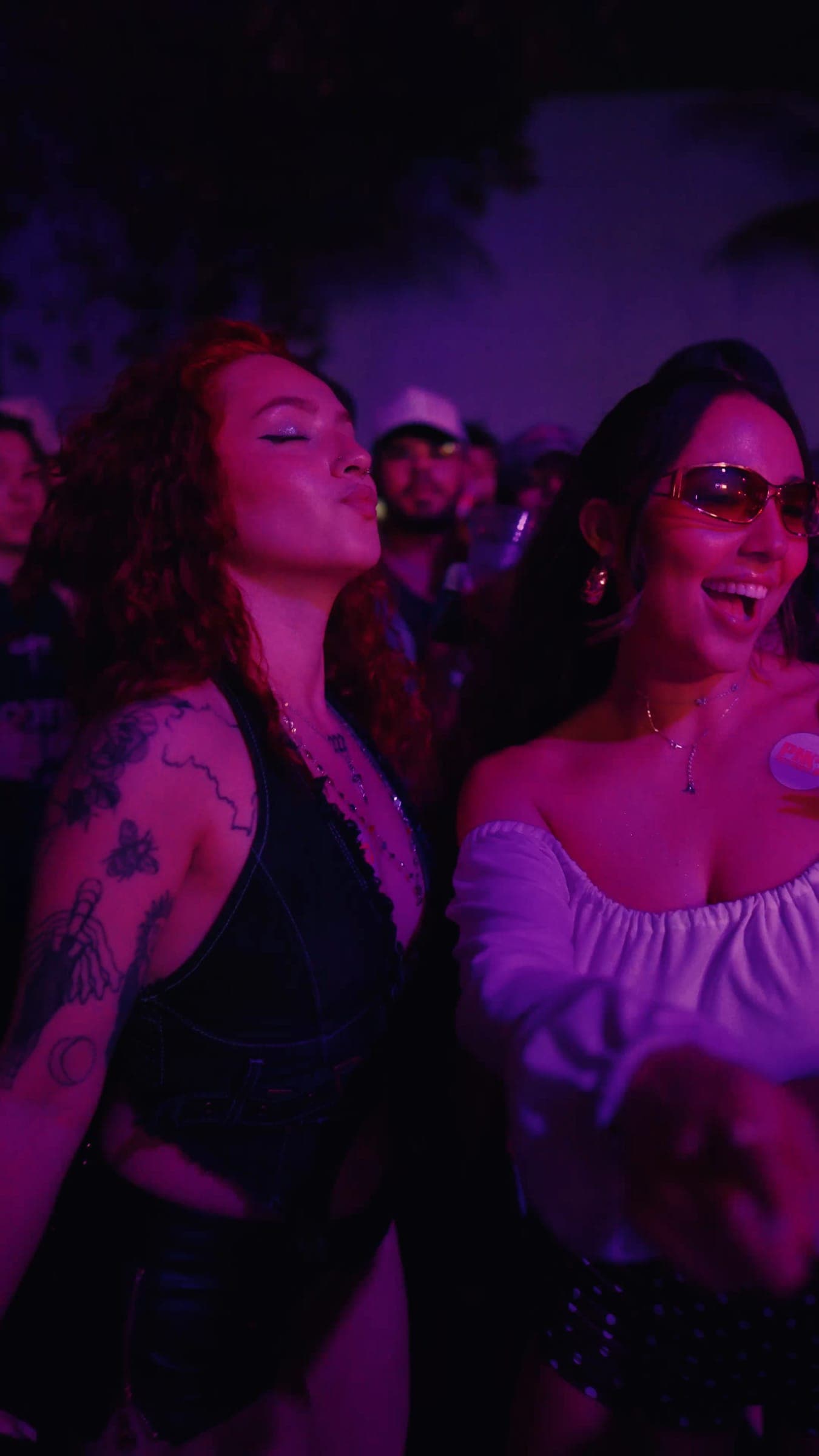 Two friends dancing in magenta light